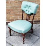 A MAHOGANY FRAMED LOW CHAIR, upholstered in green fabric and raised on casters H 77cm