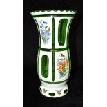 A GREEN AND OPAQUE WHITE FLASH CUT GLASS VASE with enamelled floral decoration, 26cm high