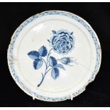 AN 18TH CENTURY DUTCH DELFT PLATE decorated with a rose within geometric border, 22cm diameter