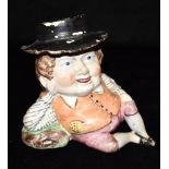 AN UNUSUAL 19TH CENTURY STAFFORDSHIRE TOBY JUG modelled in a reclining seated pose, supported by his