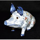 A FRENCH FAIENCE FIGURAL QUILL HOLDER modelled as a seated pig, with glass eyes, probably