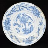 AN 18TH CENTURY DELFT SHALLOW BOWL possibly Bristol, the centre decorated with flowers and a pair of