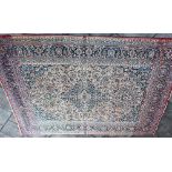 A LARGE RED GROUND CARPET with central medallion and floral decoration within multiple borders,