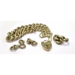A SILVER CURB LINK BRACELET fitted with a silver heart padlock and safety chain with spare links,