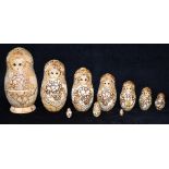 A SET OF TEN RUSSIAN MATRYOSHKA OR NESTING DOLLS with pokerwork, painted and gilt decoration, the