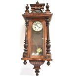 A CONTINENTAL WALNUT CASED WALL CLOCK with 8-day spring driven movement, 35cm wide 102cm high