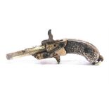 A NOVELTY MINIATURE PISTOL with foliate engraved grip plates, 4.5cm long.