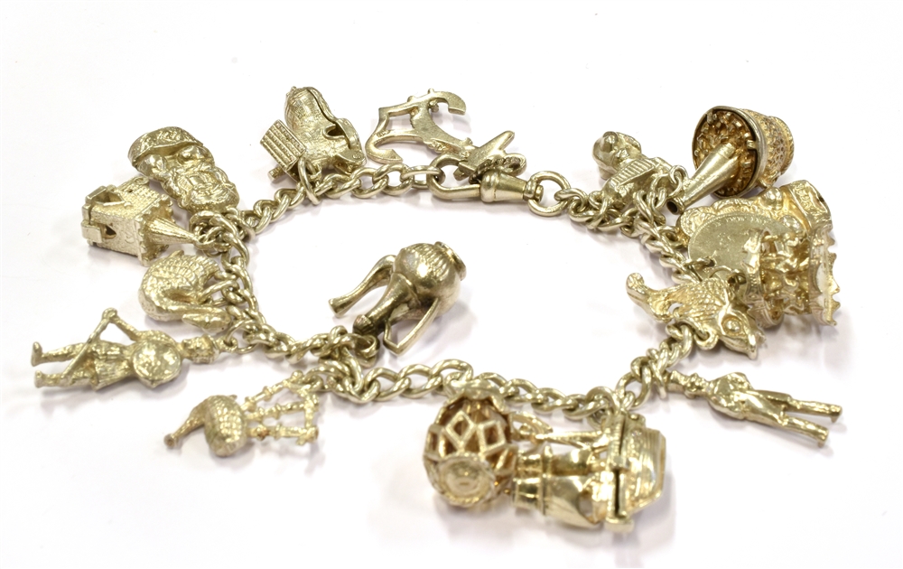 A SILVER AND WHITE METAL CHARM BRACELET weighing 57.6grams