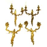 A SET OF FOUR GILT METAL TWO LIGHT WALL LIGHTS in the Rococo taste, 38cm high 32cm wide Condition