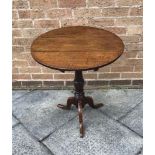 A 19TH CENTURY OAK OCCASIONAL TABLE raised on a central column, with a tripod base, H 70cm