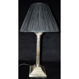 A TABLE LAMP WITH SILVER PLATED CORINTHIAN COLUMN BASE with black pleated shade 56cm high overall