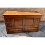 AN OAK MULE CHEST of panelled construction, the top opening reveal a candle box space to the right