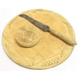 A CIRCULAR WOODEN BREAD BOARD the border carved with ears of wheat, 35.5cm diameter; a bread knife