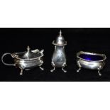 A SILVER THREE PIECE CRUET SET Complete with blue glass liners and two salt spoons, all hallmarked