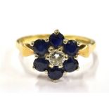 AN 18CT GOLD DIAMOND AND SAPPHIRE SLOWER HEAD RING The central round cut diamond measuring approx.