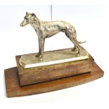 An early to mid 20th century silver plated greyhound standing on a wooden plinth base, 22.5 cms high