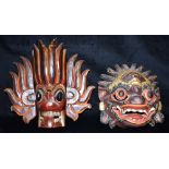 TWO CARVED WOOD WALL MASKS with painted and gilded decoration, the largest 29cm high no great age,