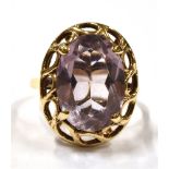A 9CT GOLD AMETHYST COCKTAIL RING the faceted oval lilac amethyst measuring 1.5cm by 1cm, mounted in