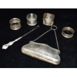 A COLLECTION OF FOUR SILVER NAPKIN RINGS Weighing 86.6 grams together with a silver handled button