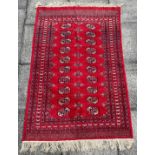 A RED GROUND RUG with two rows of guls, 125cm x 185cm