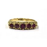 A 9CT GOLD RUBY FIVE STONE DRESS RING the five rubies set in white gold on a yellow gold shank,