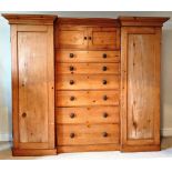 A PINE COMPACTUM with a central chest of six graduating drawers, with a twin door unit to the top,