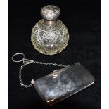A GEORGE V SILVER PURSE And a silver topped cut glass scent bottle, the silver purse of plain form