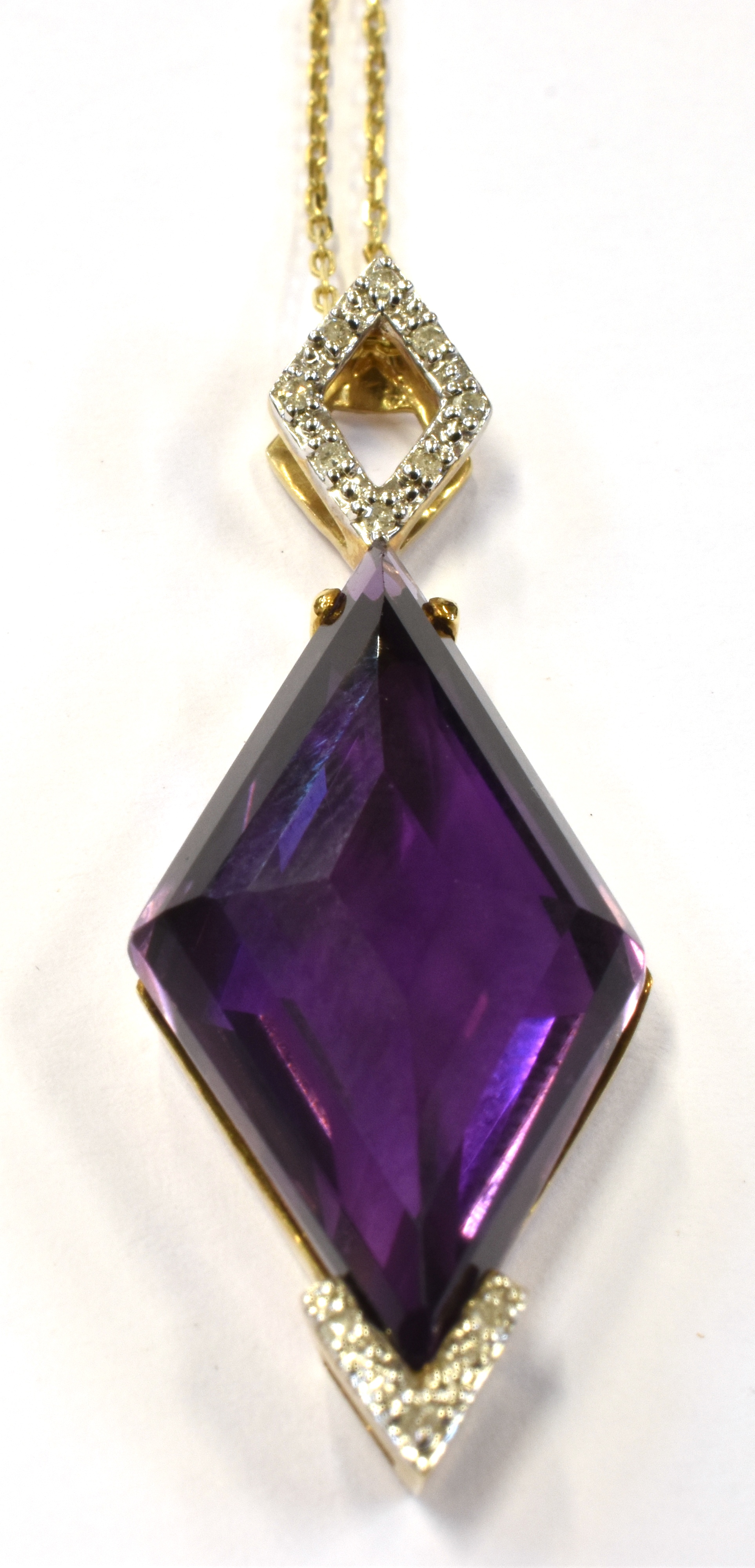 A 9CT GOLD DIAMOND ACCENTED AMETHYST ABSTRACT PENDANT the deep purple amethyst suspended on a tagged - Image 2 of 3