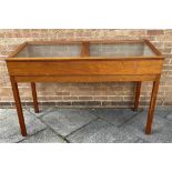 A TEAK MUSEUM DISPLAY CABINET with a pair of glazed sloping tops raised on sqaure supports, H