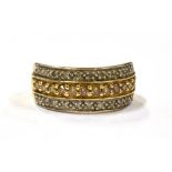 A 9CT GOLD CHAMPAGNE AND WHITE DIAMOND RING the tapered wide band ring set with a central row of