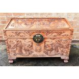 AN ORIENTAL HARDWOOD COFFER with dragon decoration to the top, front and sides, with brass