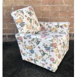 AN UPHOLSTERED CHILDREN'S ARMCHAIR decorated in floral upholstery H 52cm x W 49cm x D 43cm