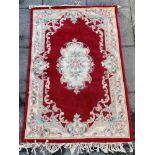 A RED GROUND CHINESE RUG 119cm x 180cm