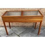 A TEAK MUSEUM DISPLAY CABINET with a pair of glazed sloping tops raised on sqaure supports, H