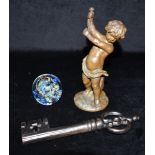 A PATINATED SPELTER FIGURE OF A CHERUB 20cm high, a large key 22cm long, and a glass paperweight