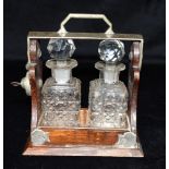 A MINATURE TWO BOTTLE SCENT FLASK TANTALUS the EPNS frame stamped 'THE TANTALUS', 13cm wide 14.5cm