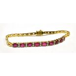 AN 18CT GOLD, RUBY AND DIAMOND TENNIS BRACELET the bracelet half set with nine facetted oval