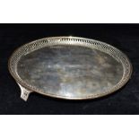 AN EDWARDIAN SILVER TRAY The circular tray with raised openwork border standing on 3 matched