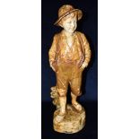 A GOLDSCHEIDER TERRACOTTA FIGURE OF A BOY wearing a waistcoat, standing with his hands in his
