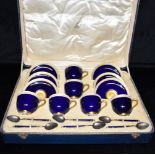A ROYAL WORCESTER CASED SET OF SIX CUPS AND SAUCERS and six matching silver and enamel spoons, the