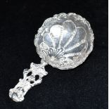 A SILVER CADDY SPOON the spoon handle featuring an embossed cameo, the large bowl with fancy design,