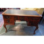 A MAHOGANY KNEEHOLE DESK with leather insert to the top, with a central drawer, flanked to each side