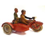A TIPP & CO. TINPLATE MOTORCYCLE & SIDECAR lithographed in lined red, with rider, pillion and