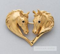 A Harriet Glen 9ct gold and blue sapphire horsehead heart brooch, modelled as two horse heads with