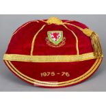 Red Wales International cap awarded in 1975-76, the red velvet with gilt tassel and braiding,