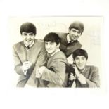 The Beatles: A large photograph signed by all four members of the band.