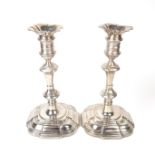 A pair of George II cast silver candlesticks