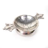 A rare George VI twin handled tea strainer and stand