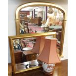 A gilt overmantle mirror, 80cm high x 88cm wide, a gilt wall mirror and a lamp (3) Condition Report: