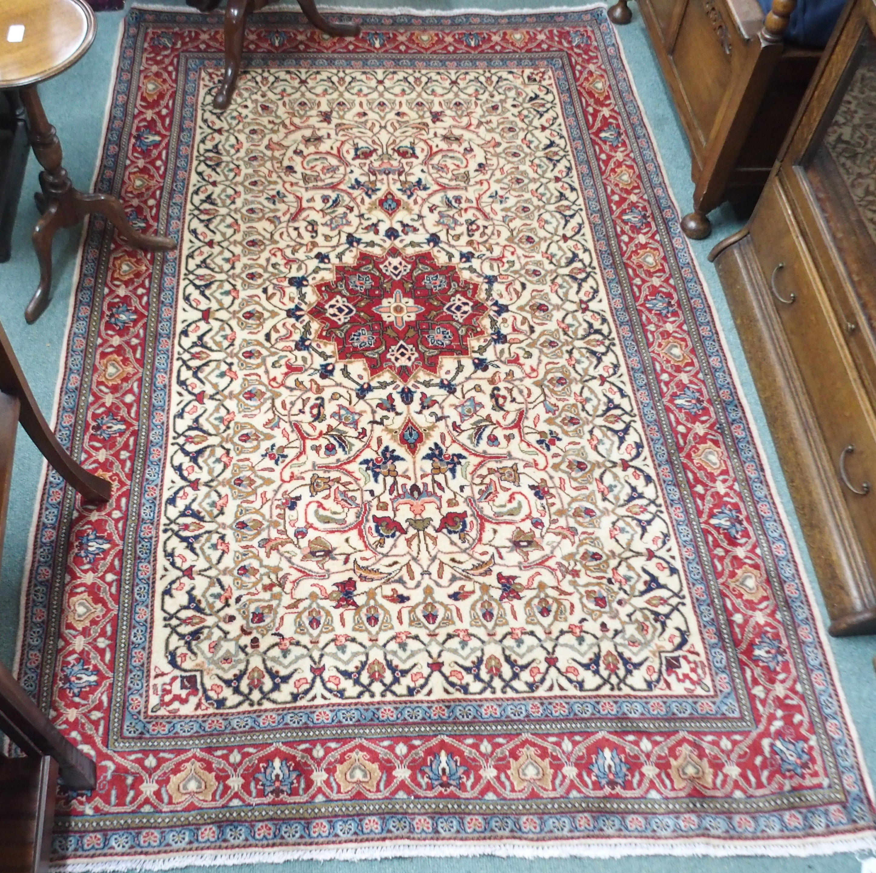 A cream ground Keshan rug with red central medallion and border, 208cm x 132cm Condition Report: